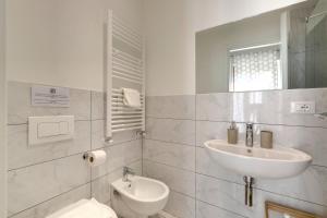 bagno bianco con lavandino e servizi igienici di Sleep Tight Florence (Rooms) a Firenze