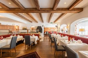 uma sala de jantar com mesas e cadeiras brancas em Alte Schmiede Hiltpolt em Seefeld no Tirol