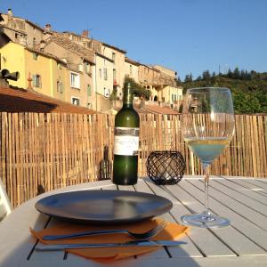 a bottle of wine and a glass on a table at Bel appartement, terrasse plein sud, Vieux Village in Roquebrun +5 photos