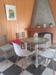 stół i krzesła w pokoju z kominkiem w obiekcie Casa Belen I y II w mieście Madroñal