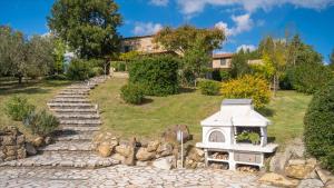 a garden with a dog house on a stone path at Cinque Cipressi 8, Emma Villas in Montecatini Val di Cecina