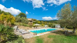 a swimming pool in a yard with a house at Cinque Cipressi 8, Emma Villas in Montecatini Val di Cecina