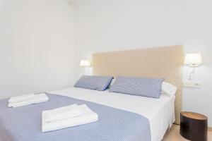 a bedroom with a bed with two blue pillows at Villa Can Ginebra in Sant Josep de Sa Talaia