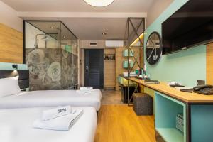 a hotel room with two beds and a desk at Hotel Urban in Plovdiv