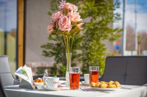 a table with a vase of pink roses on it at Hotel Urban in Plovdiv