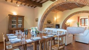 Un comedor con una mesa y un sofá. en Il Fitto 10, Emma Villas, en Cortona