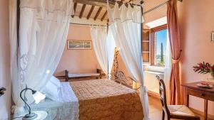 Un dormitorio con una cama con dosel y una ventana. en Il Fitto 10, Emma Villas, en Cortona 51 fotos más