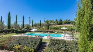 una piscina con sillas y sombrillas en un jardín en Il Fitto 10, Emma Villas, en Cortona