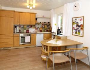 kuchnia z drewnianymi szafkami oraz drewnianym stołem i krzesłami w obiekcie Haus Tannenweg w mieście Zell an der Mosel