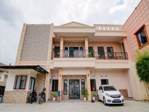 une maison avec une voiture garée devant elle dans l'établissement OYO 90233 The Shine Residence, à Pekanbaru