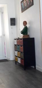 a statue of a man sitting on top of boxes at La Maison de Soso in Chambon-le-Château