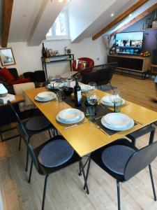 una mesa de madera con sillas, platos y copas de vino en Apartment Gloria3, en Marina