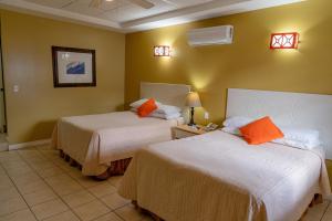 a hotel room with two beds with orange pillows at Hotel Casona del Lago in Flores