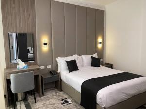 亚的斯亚贝巴ECCO Modern Guest House的酒店客房配有一张床、一张书桌和一台电视。 更多35张照片