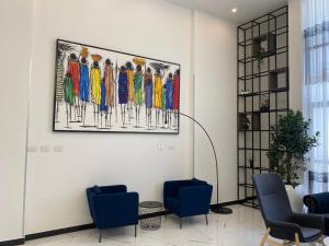 un soggiorno con sedie e un dipinto sul muro di ECCO Modern Guest House ad Addis Abeba