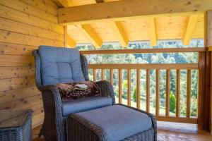 una silla de mimbre sentada en un porche en una cabaña en Gasserhof Chalets, en Meltina