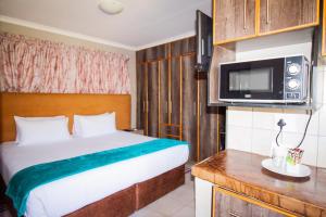 ein Hotelzimmer mit einem Bett und einer Mikrowelle in der Unterkunft PW Heights Private Guest House in Thohoyandou