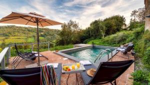 patio con tavolo, ombrellone e piscina di PODERE DELLE SORGENTI 4&2, Emma Villas a Orvieto