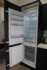 an empty refrigerator with its door open in a kitchen at Millers Cottage in Berwick-Upon-Tweed