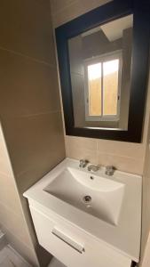 a bathroom with a white sink and a mirror at 3 ambientes - Departamento reciclado a nuevo a 250m del mar in Miramar +2 photos