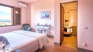 sypialnia z łóżkiem oraz łazienka z umywalką w obiekcie VILLA IL FORAMASSO 10&2, Emma Villas w mieście Lucciana +37 zdjęć