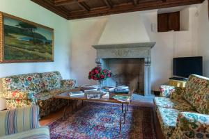 a living room with a table and a fireplace at Villa Palazzaccio 26, Emma Villas in Arezzo