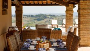 una mesa con tazas y platos en el patio en Villino Bruna 6, Emma Villas en Bertinoro