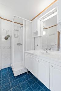 a white bathroom with a sink and a shower at Fishermans Village Lofoten in Alstad +30 photos