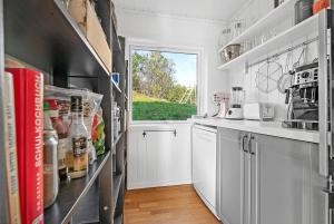 a kitchen with white cabinets and a window at Fishermans Village Lofoten in Alstad