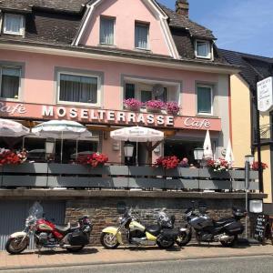 un groupe de motocycles garés devant un bâtiment dans l'établissement Cafe Moselterrasse, à Klotten