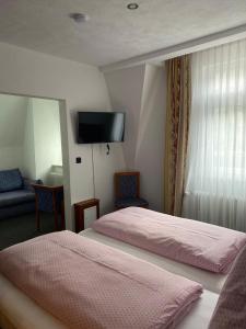 a hotel room with two beds and a flat screen tv at Cafe Moselterrasse in Klotten