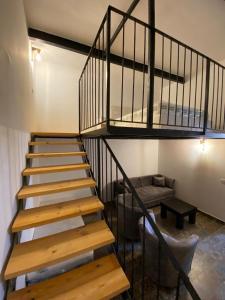 uma escada em espiral num quarto com um sofá em יחידת נופש בבית ורדי em Tiberias