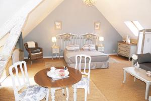 a bedroom with a bed and a table and chairs at Les Pérelles in Saint-Vigor-le-Grand