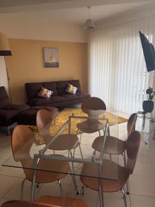 a living room with a couch and a table and chairs at Pafilia Garden Apartments in Paphos