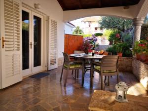 a patio with a table and chairs on a patio at Apartmani Rita Kiwi in Novigrad Istria