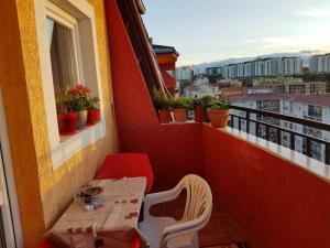uma pequena mesa e cadeira numa varanda com plantas em ONE bedroom apartment - close the CITY CENTER! PRISHTINA em Pristina