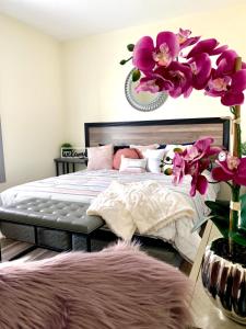 a bedroom with a bed with purple flowers on it at The Eastside Manor- With Private Yard & Free Parking, Minutes From Falls & Casino by Niagara Hospitality in Niagara Falls
