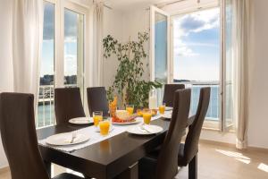 een eetkamer met een tafel, stoelen en ramen bij Design Apartment Bellevue in Poreč