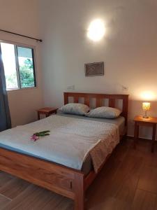 a bedroom with a bed with a flower on it at Magic Mountain Lodge in Las Lajas