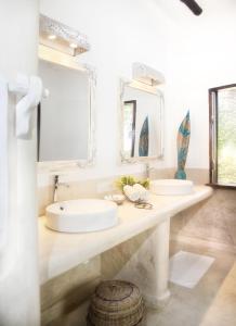 a bathroom with two sinks and a large mirror at Temple Point Resort in Watamu