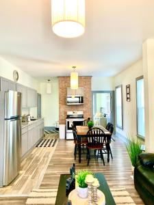 a kitchen and living room with a table and chairs at The Iron Scow - With Private Yard & Free Parking, Minutes From Falls & Casino by Niagara Hospitality in Niagara Falls