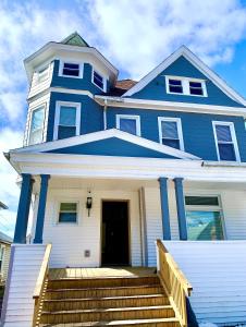 a blue house with stairs in front of it at The Iron Scow - With Private Yard & Free Parking, Minutes From Falls & Casino by Niagara Hospitality in Niagara Falls