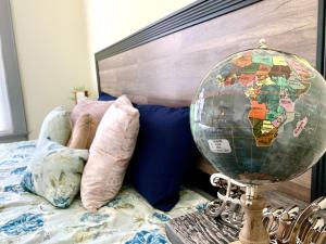 a globe sitting next to a bed with pillows at The Iron Scow - With Private Yard & Free Parking, Minutes From Falls & Casino by Niagara Hospitality in Niagara Falls