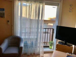 ロザスにあるApartamento Figueres 12のリビングルーム(白いカーテン付きの大きな窓付)
