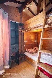 Cette cabane en rondins comprend des lits superposés et une échelle. dans l'établissement Résidence Les hauts de Val Cenis, à Lanslevillard
