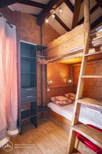 a log cabin with a bunk bed and a ladder at Résidence Les hauts de Val Cenis in Lanslevillard