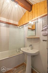 a bathroom with a sink and a shower and a tub at Résidence Les hauts de Val Cenis in Lanslevillard +3 photos