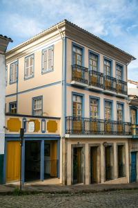 un gran edificio blanco con balcones en una calle en Pousada Solar da Ópera, en Ouro Preto