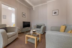 een woonkamer met 2 banken en een salontafel bij Alexandra Lodge in Swansea
