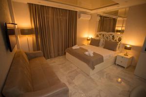a bedroom with a bed and a couch and a mirror at Lux Apartment in Batumi